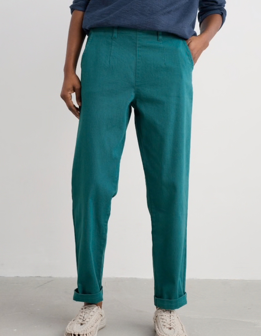 Person wearing teal pants and a blue shirt on a white background