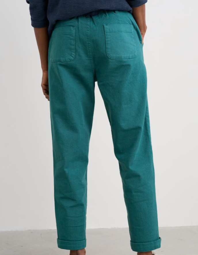 Teal pants worn by a person on a white background