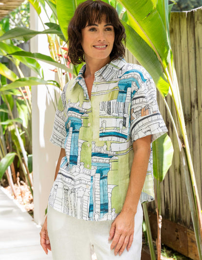 Woman wearing a patterned shirt standing among green plants