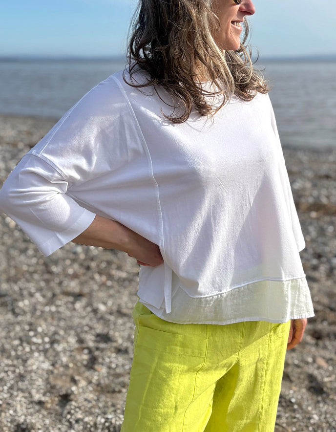 woman wearing oversized white cotton jersey top and citron yellow linen trousers
