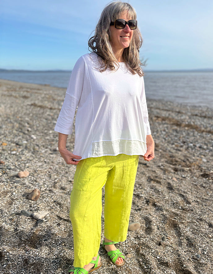 woman wearing oversized white cotton jersey top and citron yellow linen trousers