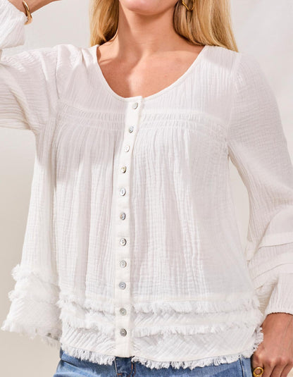 White textured blouse with buttons worn by a person, against a neutral background