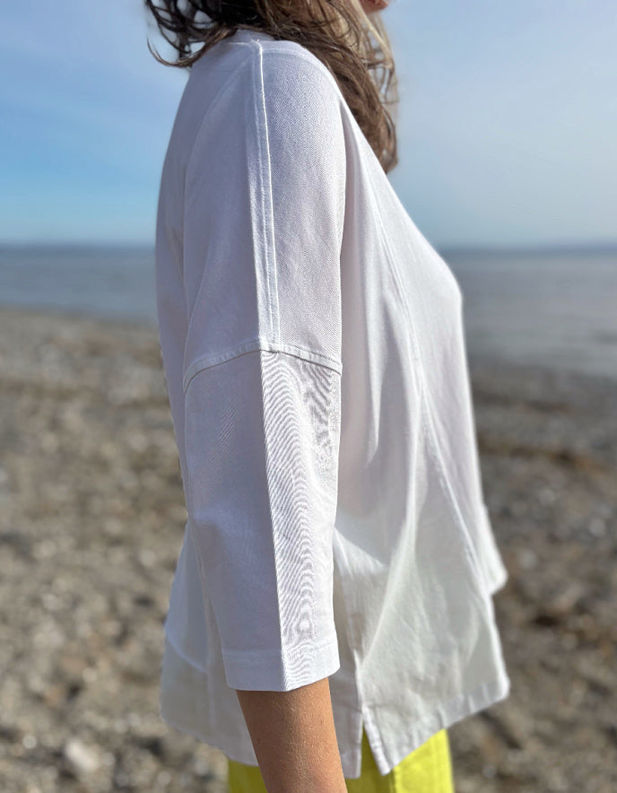 woman wearing oversized white cotton jersey top and citron yellow linen trousers