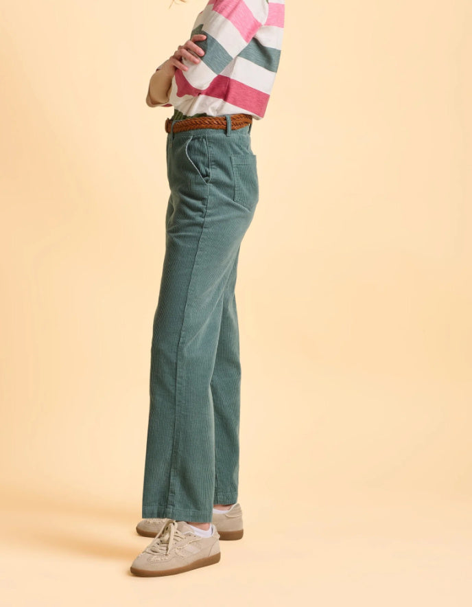 Person wearing teal pants and a checkered shirt on a beige background
