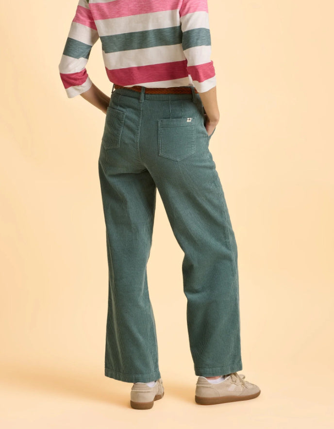 Person wearing a striped shirt and green pants on a beige background