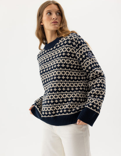 Woman wearing a navy and beige patterned sweater on a white background