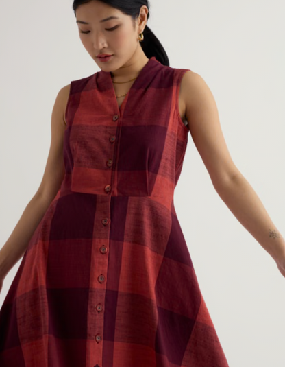 Woman wearing a red plaid dress against a plain background
