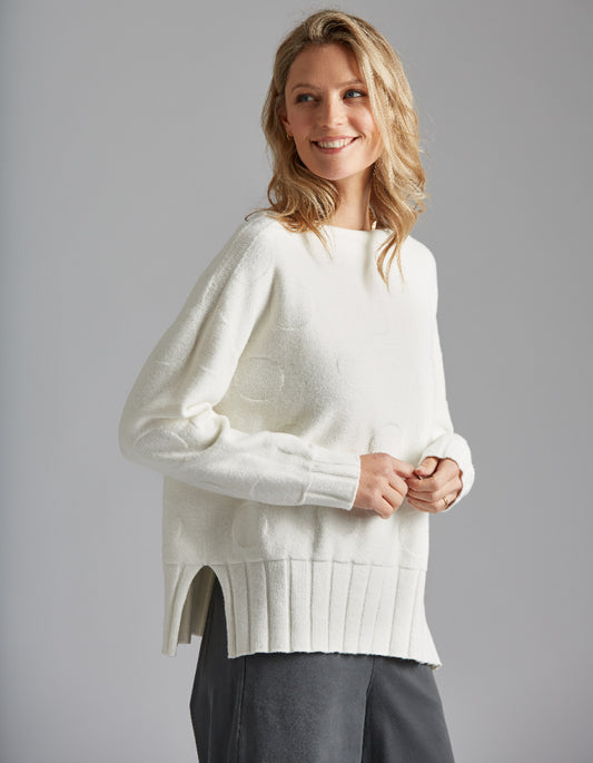 Woman wearing a white sweater with a gray background