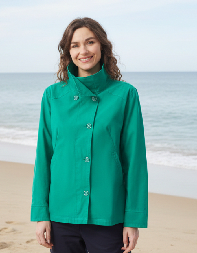 Woman wearing a green jacket on a beach
