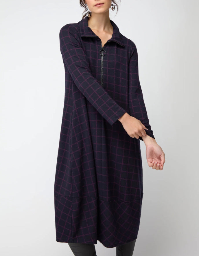 Woman wearing a long dark plaid bubble dress on a white background