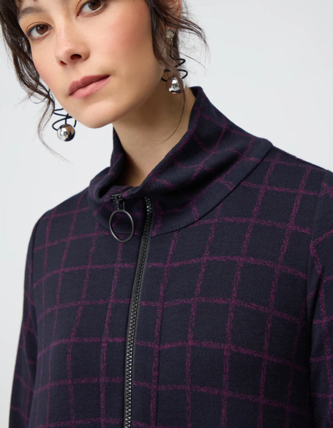 Woman wearing a long dark plaid bubble dress on a white background