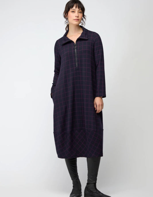 Woman wearing a long dark plaid bubble dress on a white background