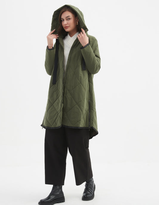 Woman wearing a green quilted jacket on a white background