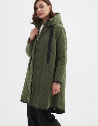 Woman wearing a green quilted jacket on a white background