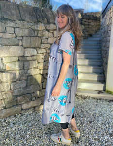bamboo silk dress with loose shaped fit and pin tuck darting down each side at the front, grey background with turquoise blue bubble print with white and grey striped fish, lovely soft silky feel