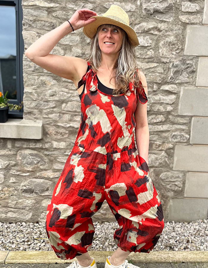 cotton sleeveless jumpsuit 3/4 length leg with loose balloon  shape and elasticated cuffs, tie shoulder straps in red with black and sand dash print