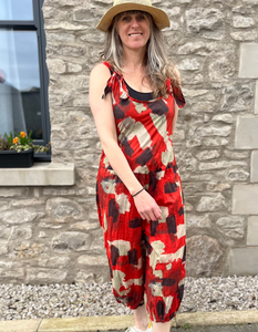 cotton sleeveless jumpsuit 3/4 length leg with loose balloon shape and elasticated cuffs, tie shoulder straps in red with black and sand dash print