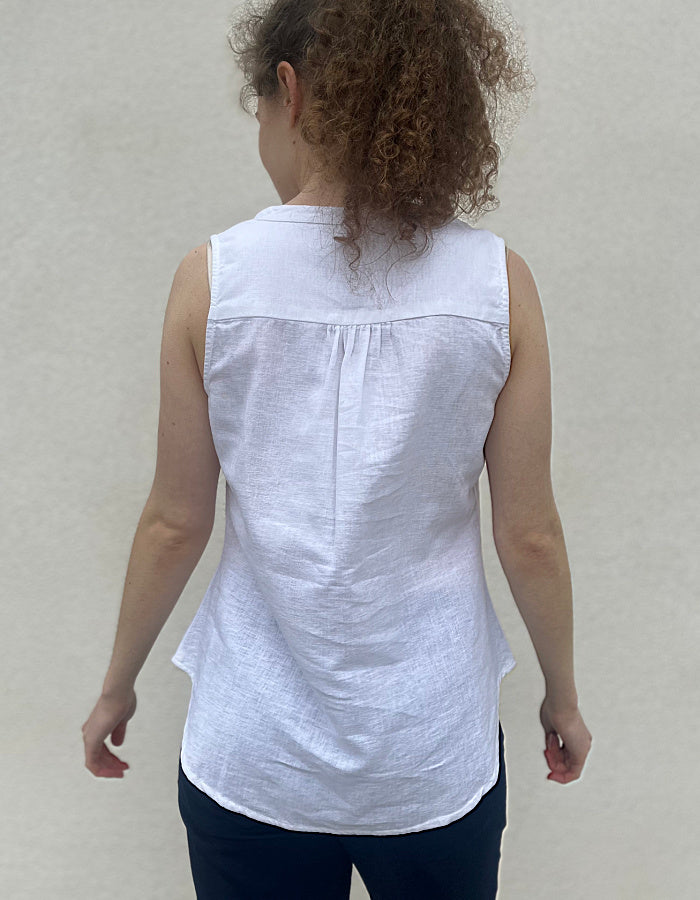 white cotton linen sleeveless sun top with cut out neckline and front pleat for slight swing